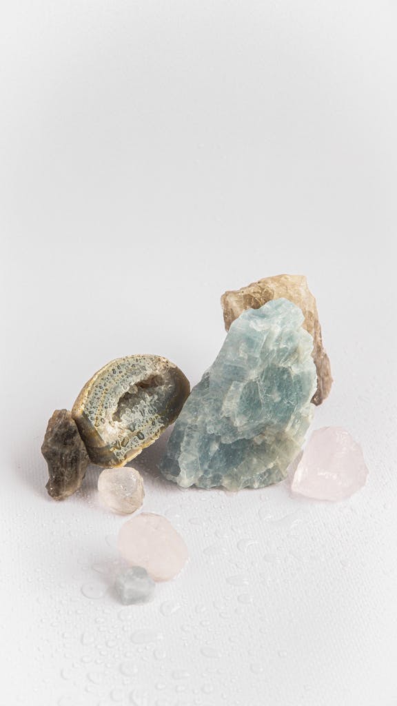 A collection of various healing crystals and stones arranged on a white background, showcasing their natural beauty.