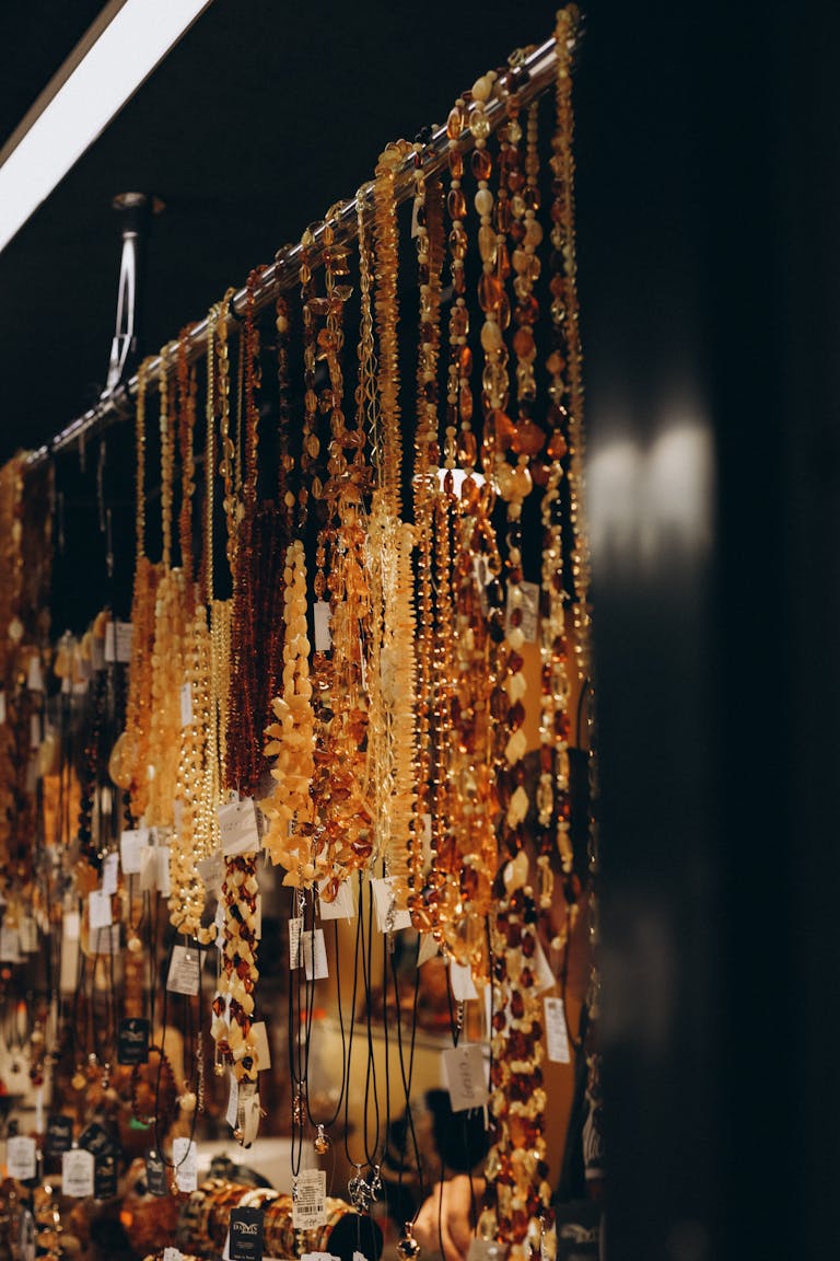 An exquisite assortment of amber necklaces hanging in a sophisticated indoor boutique display.
