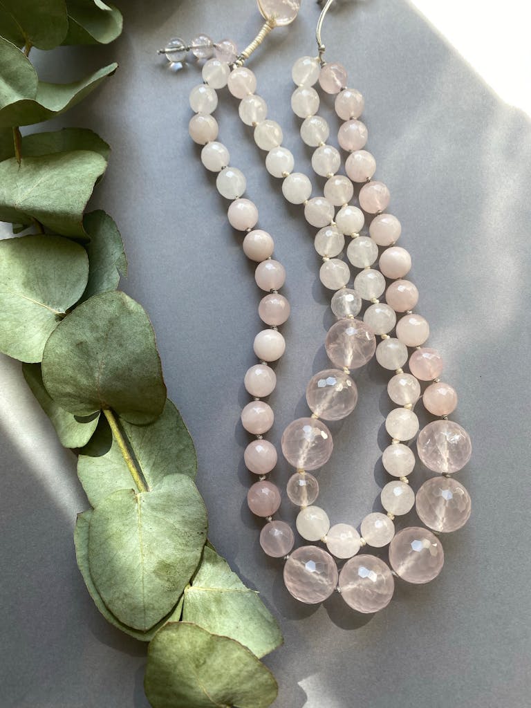 Stylish rose quartz necklace with eucalyptus leaves, perfect for gifts or fashion jewelry.