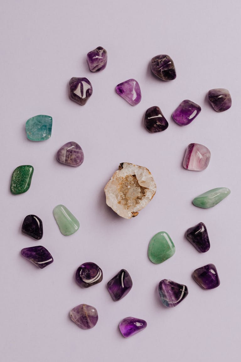 A collection of colorful tumbled gemstones artfully arranged on a neutral background.