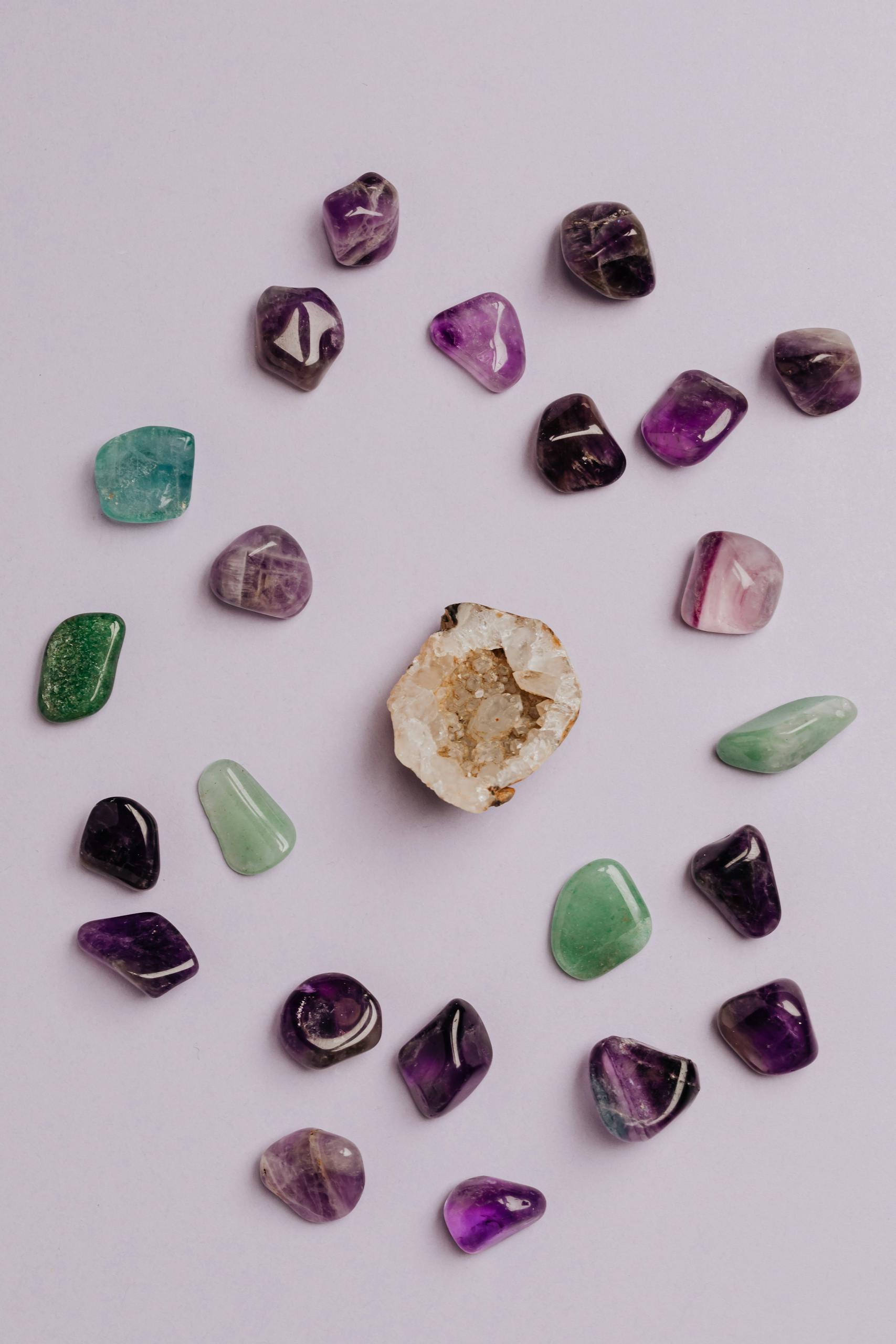 A collection of colorful tumbled gemstones artfully arranged on a neutral background.